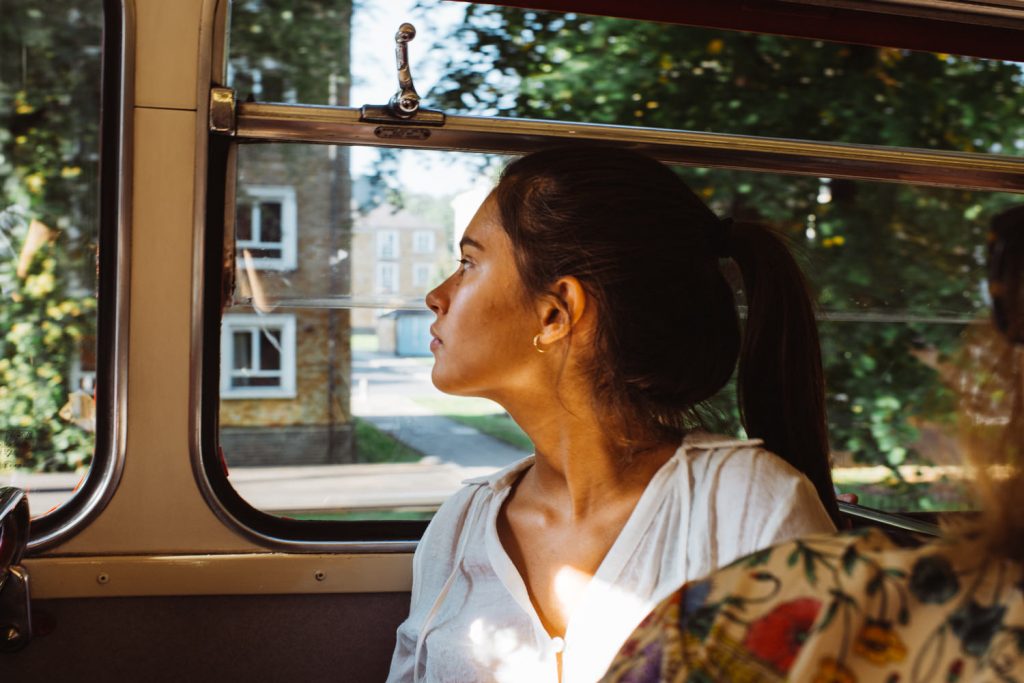 Young woman in London red bus during wedding