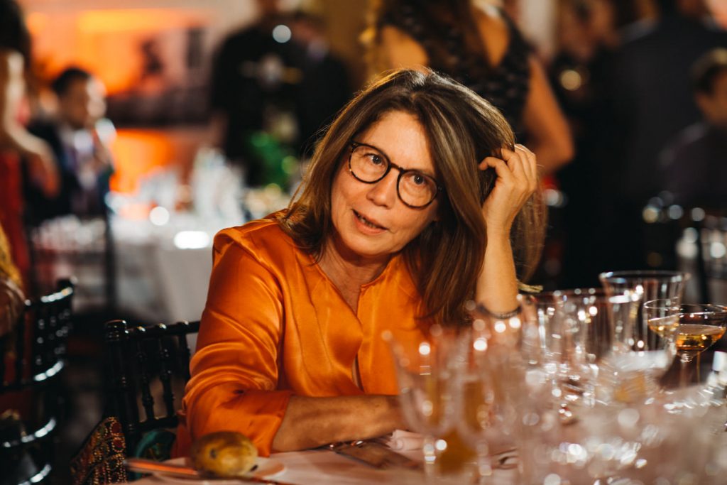 Woman at table ine orange silk blouse